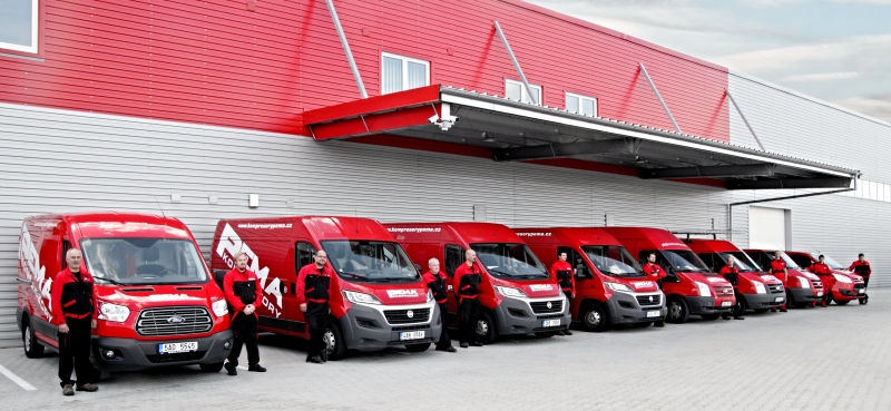 Servisní tým PEMA u červených servisních vozidel před firemním zázemím